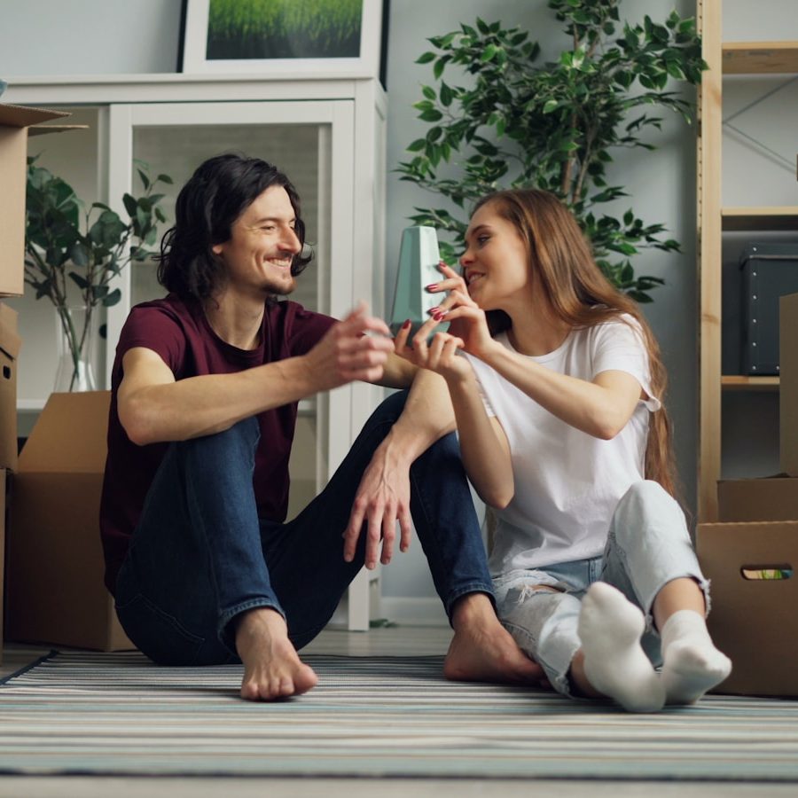 a man and a woman sitting on the floor surrounded by boxes